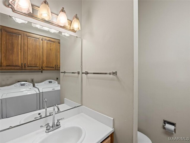 1520 Meriwether Rd, Montgomery, AL 36117 - bathroom with washing machine and clothes dryer, vanity, and toilet