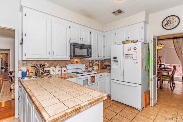 3146 Malone Dr, Montgomery, AL 36106 - kitchen featuring white cabinets, tile countertops, white appliances, and visible vents