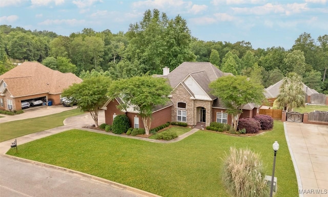 view of front facade featuring a front lawn, stone siding, a chimney, a gate, and concrete driveway