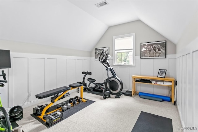 exercise area featuring vaulted ceiling, carpet floors, a decorative wall, and visible vents