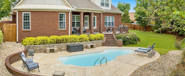 view of swimming pool featuring a lawn, a patio, outdoor dining area, and a fenced backyard