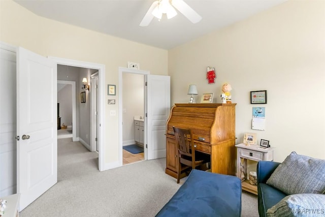office area featuring baseboards, ceiling fan, and light carpet