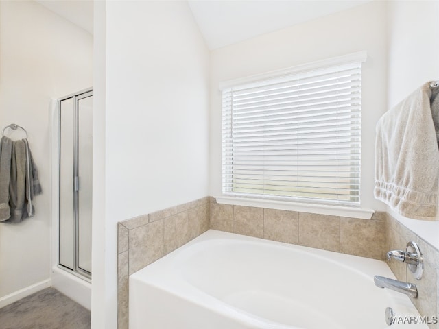 bathroom with a stall shower, a bath, and lofted ceiling