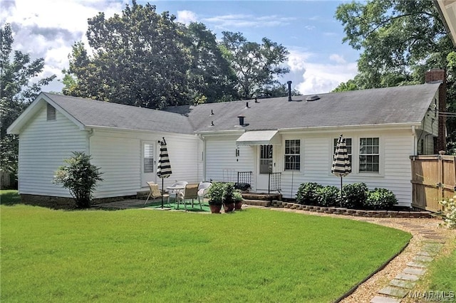 908 W Tuskeena St, Wetumpka, AL 36092 - rear view of property featuring a yard, a patio, fence, and a chimney