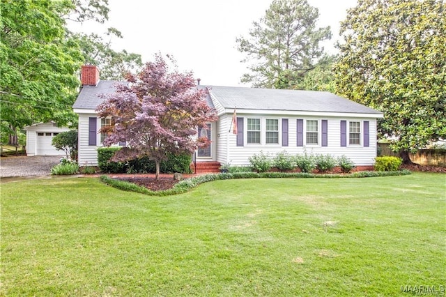 908 W Tuskeena St, Wetumpka, AL 36092 - view of front of house featuring an outbuilding, a chimney, a front yard, and a garage