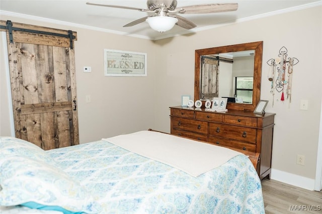 2755 Cherokee Trl, Tallassee, AL 36078 - bedroom with ornamental molding, wood finished floors, baseboards, ceiling fan, and a barn door