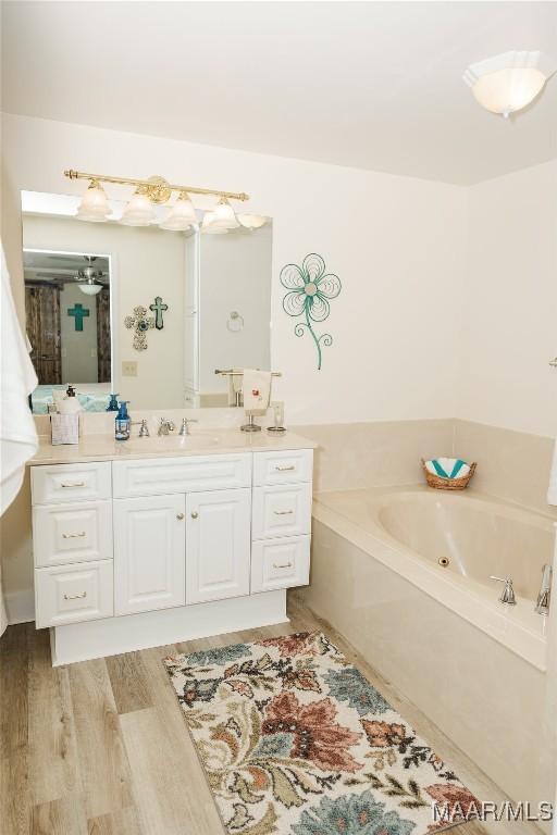 2755 Cherokee Trl, Tallassee, AL 36078 - bathroom with vanity, wood finished floors, and a jetted tub