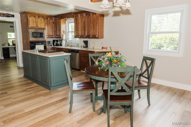 2755 Cherokee Trl, Tallassee, AL 36078 - kitchen featuring light countertops, a sink, black appliances, an inviting chandelier, and light wood-style flooring