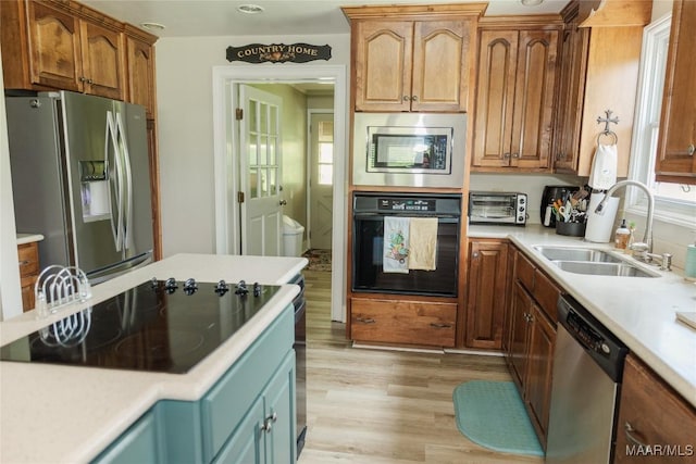 2755 Cherokee Trl, Tallassee, AL 36078 - kitchen with light wood-style floors, a sink, black appliances, and light countertops