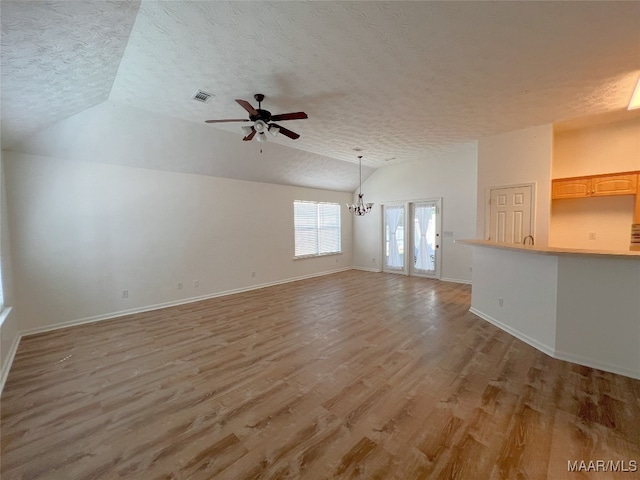 1672 Hawthorne Ln, Prattville, AL 36066 - unfurnished living room featuring baseboards, ceiling fan with notable chandelier, a textured ceiling, and lofted ceiling