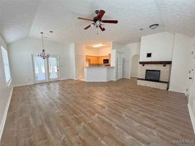 1672 Hawthorne Ln, Prattville, AL 36066 - unfurnished living room featuring light wood-style flooring, a textured ceiling, ceiling fan with notable chandelier, and vaulted ceiling