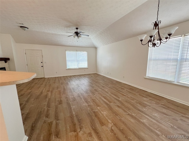 1672 Hawthorne Ln, Prattville, AL 36066 - unfurnished living room featuring light wood-type flooring, a textured ceiling, ceiling fan with notable chandelier, and baseboards