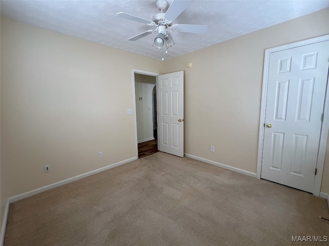 1672 Hawthorne Ln, Prattville, AL 36066 - unfurnished bedroom with baseboards, light carpet, a ceiling fan, and a textured ceiling