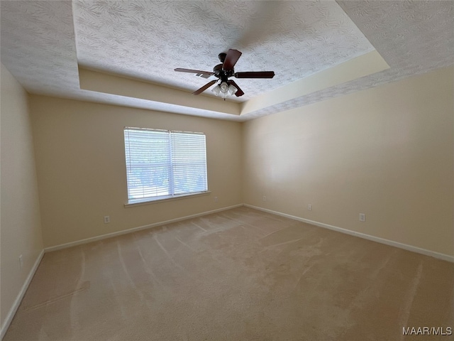1672 Hawthorne Ln, Prattville, AL 36066 - empty room with ceiling fan, light colored carpet, a textured ceiling, baseboards, and a tray ceiling
