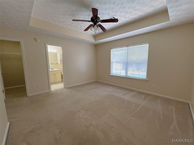 1672 Hawthorne Ln, Prattville, AL 36066 - unfurnished bedroom featuring a textured ceiling, baseboards, a spacious closet, light carpet, and a tray ceiling