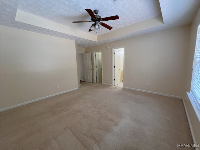 1672 Hawthorne Ln, Prattville, AL 36066 - spare room with light colored carpet, a raised ceiling, a textured ceiling, a ceiling fan, and baseboards