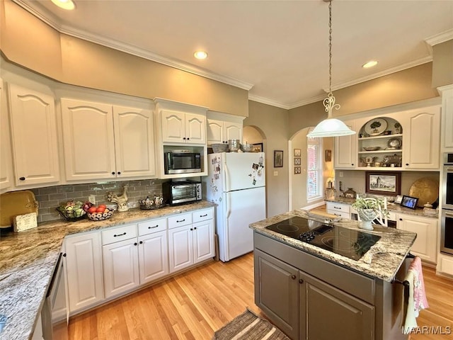 kitchen featuring crown molding, stainless steel appliances, arched walkways, and white cabinetry