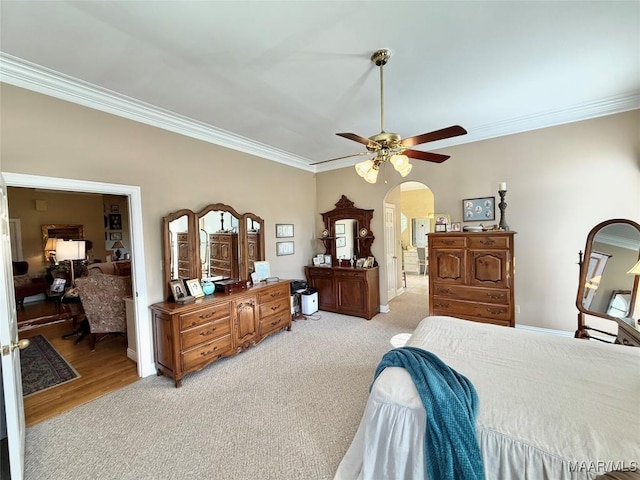bedroom featuring crown molding, arched walkways, and light carpet