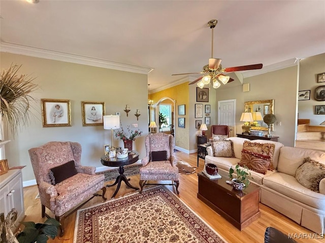 living room with baseboards, a ceiling fan, light wood finished floors, and ornamental molding