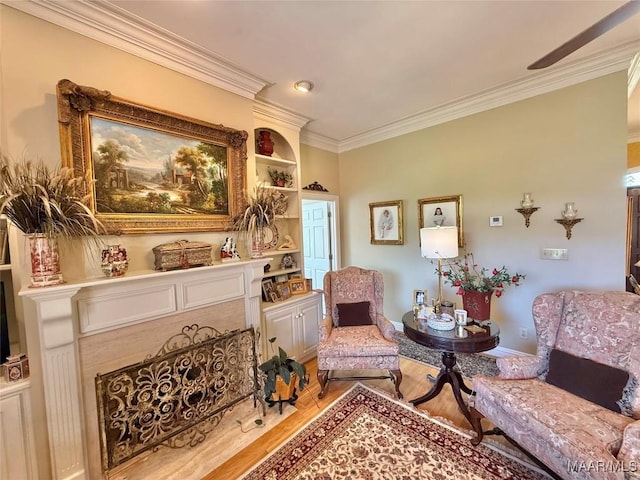 living area featuring crown molding, light wood-style floors, baseboards, and built in shelves