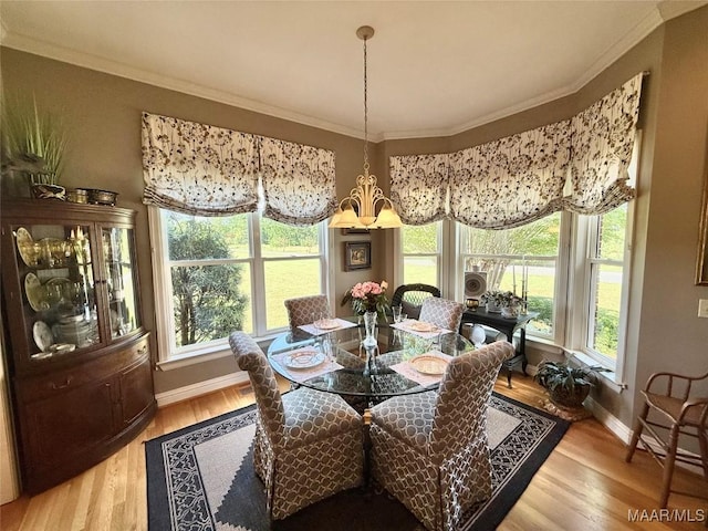 dining area with baseboards, plenty of natural light, ornamental molding, and light wood finished floors