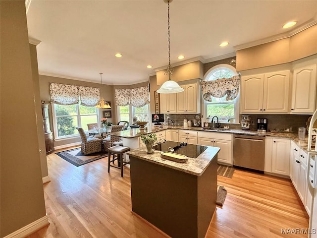 kitchen with ornamental molding, black electric cooktop, light stone counters, a sink, and dishwasher