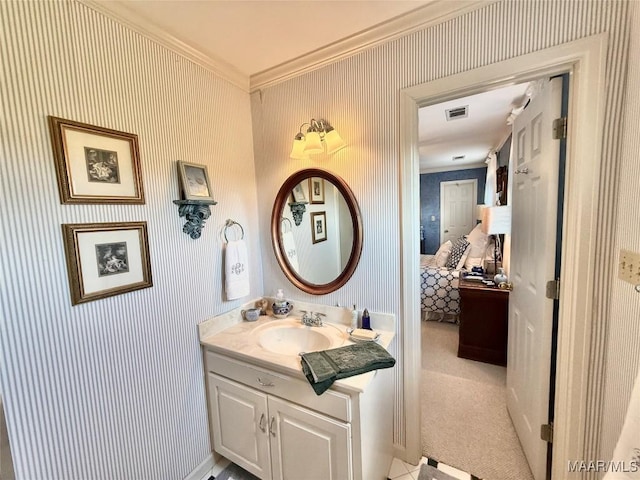 bathroom featuring vanity, ornamental molding, visible vents, ensuite bathroom, and wallpapered walls