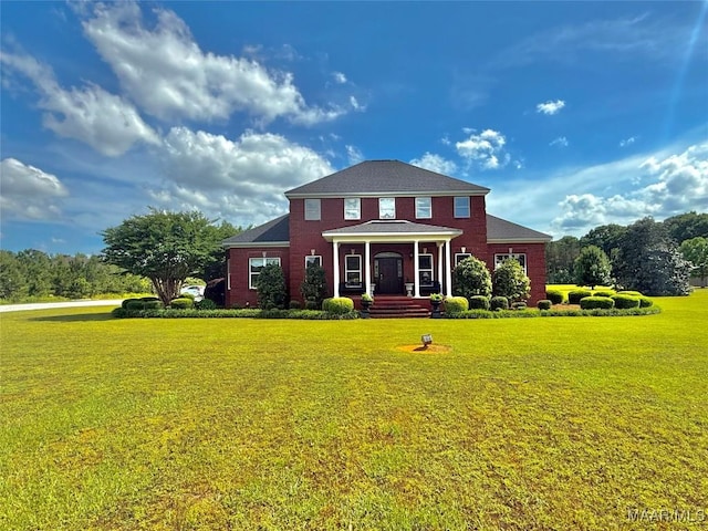 view of front facade with brick siding and a front yard