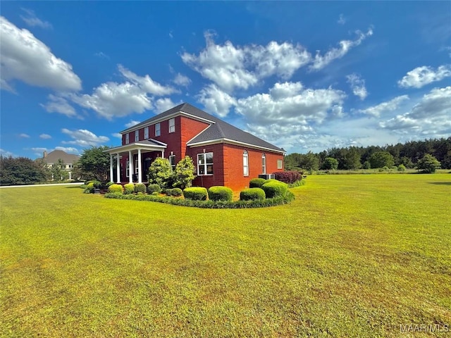 view of side of property with a yard and brick siding