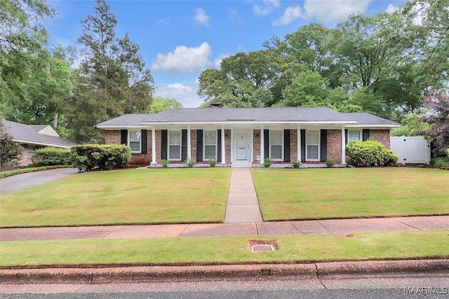 ranch-style house featuring a porch, a front lawn, and brick siding