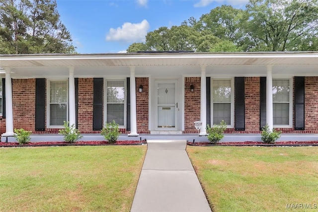 view of front of property with a porch, brick siding, and a front lawn