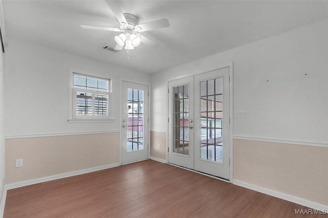 entryway featuring baseboards, a ceiling fan, wood finished floors, and visible vents