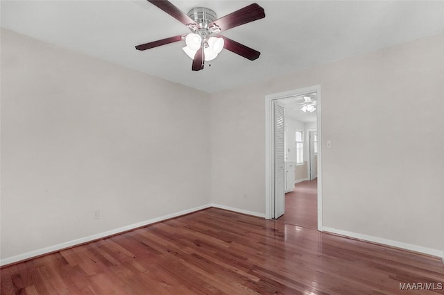 spare room with baseboards, a ceiling fan, and wood finished floors