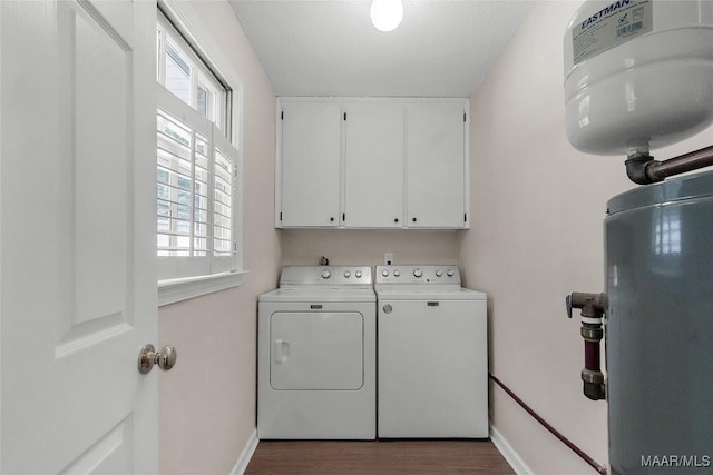 laundry area featuring baseboards, cabinet space, independent washer and dryer, and wood finished floors