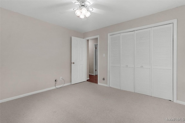 unfurnished bedroom with carpet floors, a ceiling fan, baseboards, and a closet