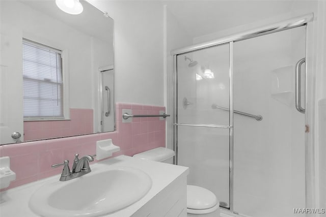 bathroom featuring vanity, a stall shower, and toilet