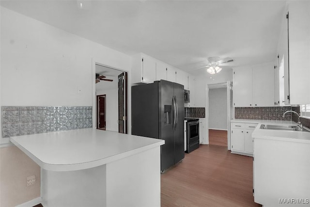 kitchen featuring a sink, stainless steel appliances, a ceiling fan, white cabinetry, and decorative backsplash