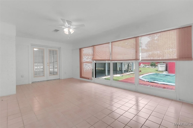 empty room featuring ceiling fan, visible vents, french doors, and tile patterned flooring