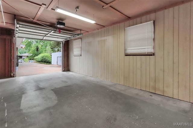 garage featuring wooden walls and a garage door opener