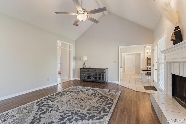 8800 Oak Meadow Ct, Montgomery, AL 36116 - living area with beam ceiling, high vaulted ceiling, a tiled fireplace, a ceiling fan, and wood finished floors
