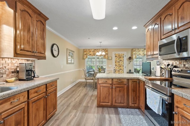 kitchen with decorative backsplash, light wood-style flooring, a peninsula, and stainless steel appliances
