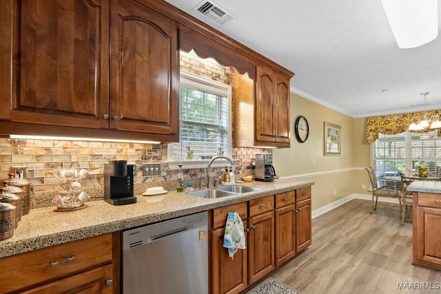 kitchen featuring backsplash, visible vents, stainless steel dishwasher, a sink, and baseboards