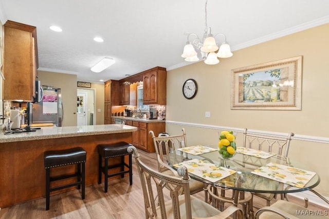 443 Fallon Ct, Deatsville, AL 36022 - dining area featuring light wood-type flooring, recessed lighting, crown molding, and a notable chandelier