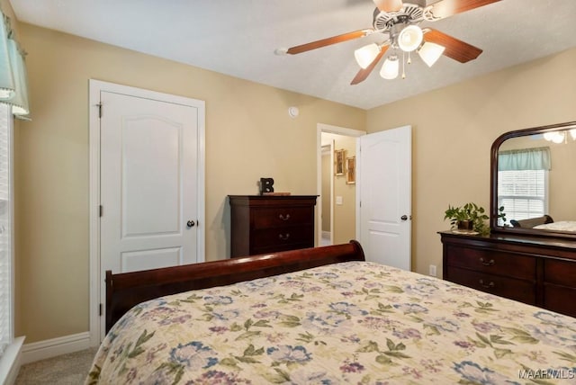 carpeted bedroom featuring a ceiling fan and baseboards
