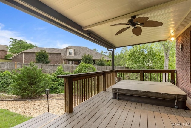 deck with a covered hot tub, a ceiling fan, and a fenced backyard