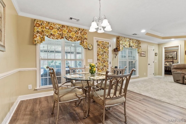 dining space featuring an inviting chandelier, ornamental molding, and visible vents