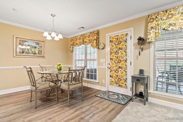 dining area with crown molding, a chandelier, visible vents, and wood finished floors