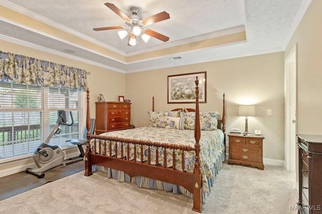 bedroom with crown molding, ceiling fan, light colored carpet, a tray ceiling, and visible vents