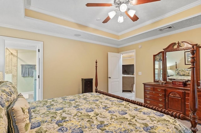 bedroom featuring visible vents, ornamental molding, baseboards, ceiling fan, and a tray ceiling