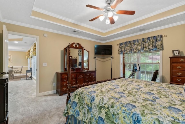 bedroom featuring light colored carpet, crown molding, a tray ceiling, and visible vents